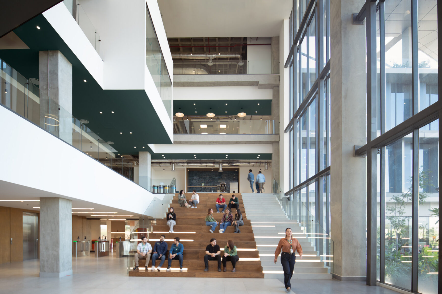 Interior photo of triple height space with people sitting on a bleacher
