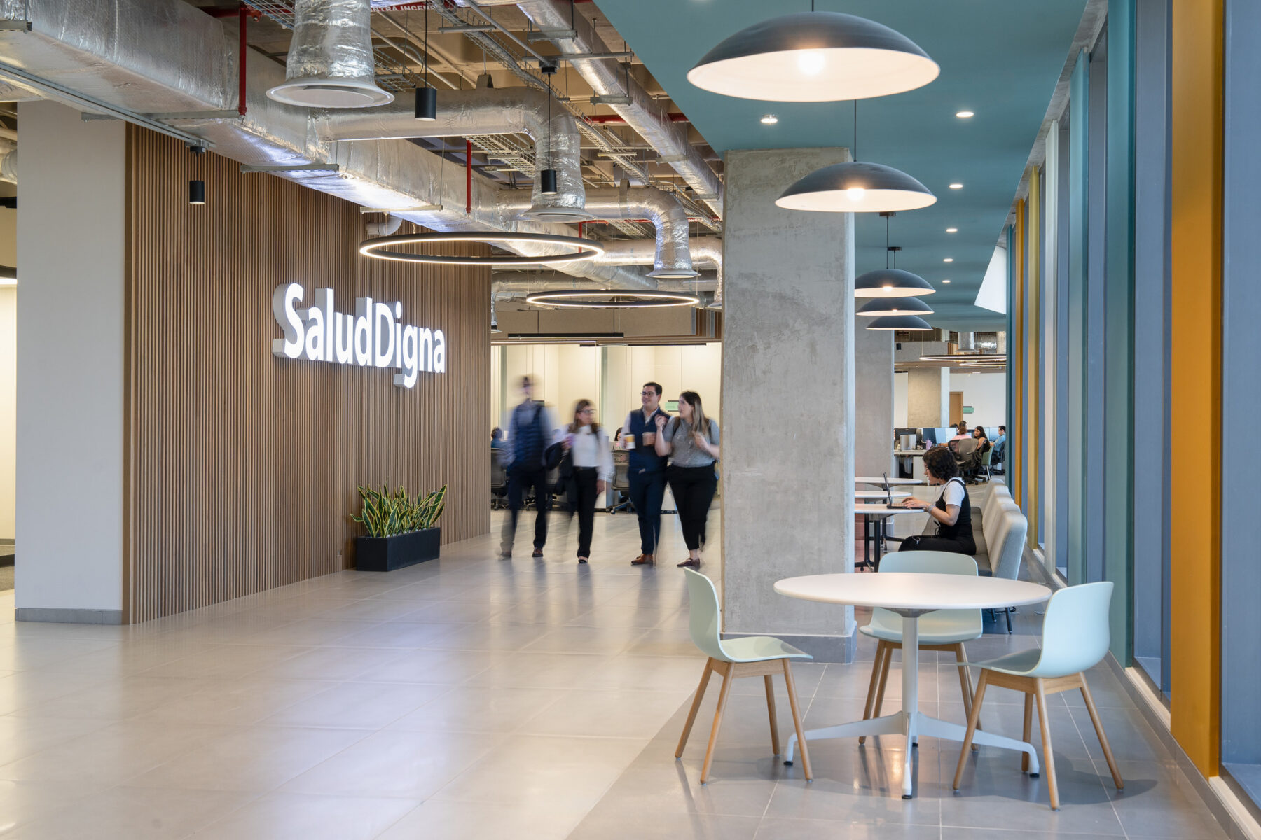 Interior photo of active hallway including Salud Digna's logo on wood paneling wall
