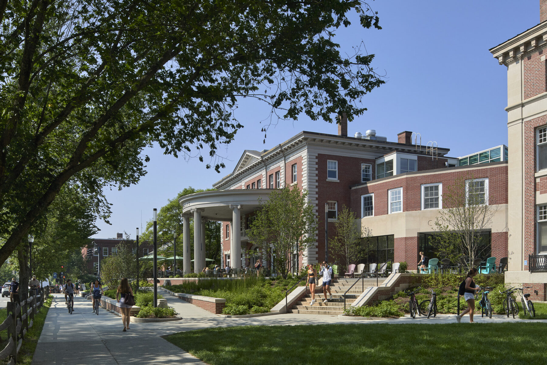 Exterior photo of the newly renovated landscape surrounding and approaching the Collis Student Center with connected sidewalks, ramps, and plantings