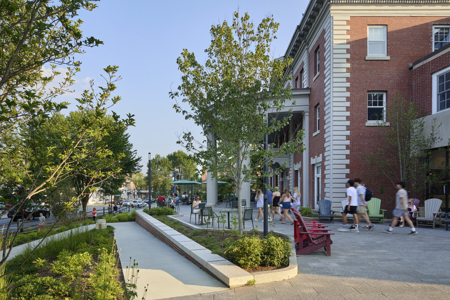 Photo of the Collis Student Center porch post-renovation with accessible ramp, plantings, and moveable furniture