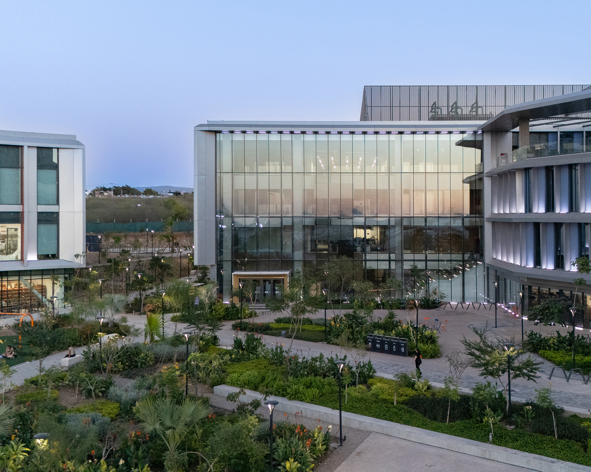 Exterior photo of Salud Digna's plaza at sunset with both the headquarters and lab building framing the edges of the frame