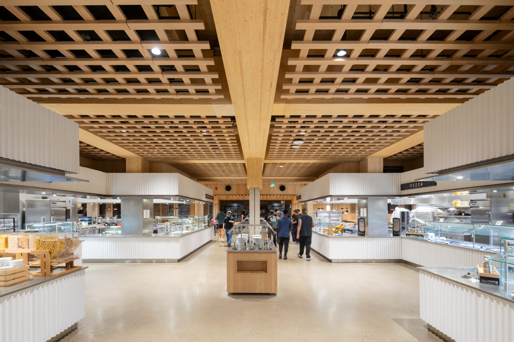 Photo of interior servery with food stations and detailed wood paneled ceiling