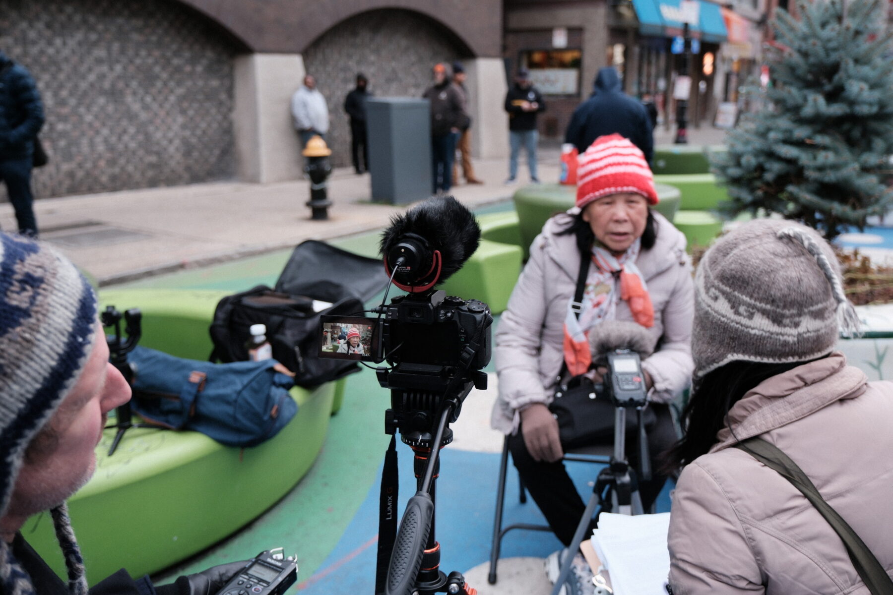 Asian woman interviewed on-site by a camera crew for a documentary about Phillips Square