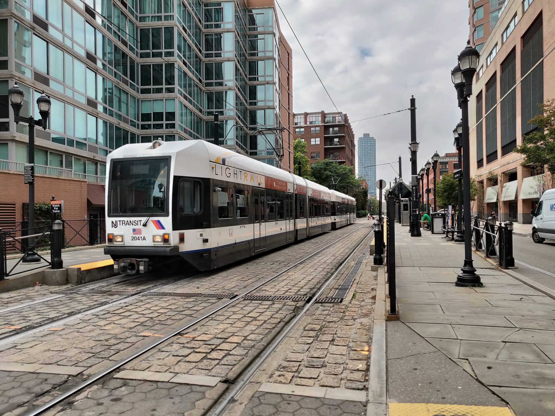 NJ TRANSIT light rail arriving at Essex Street with housing in the background